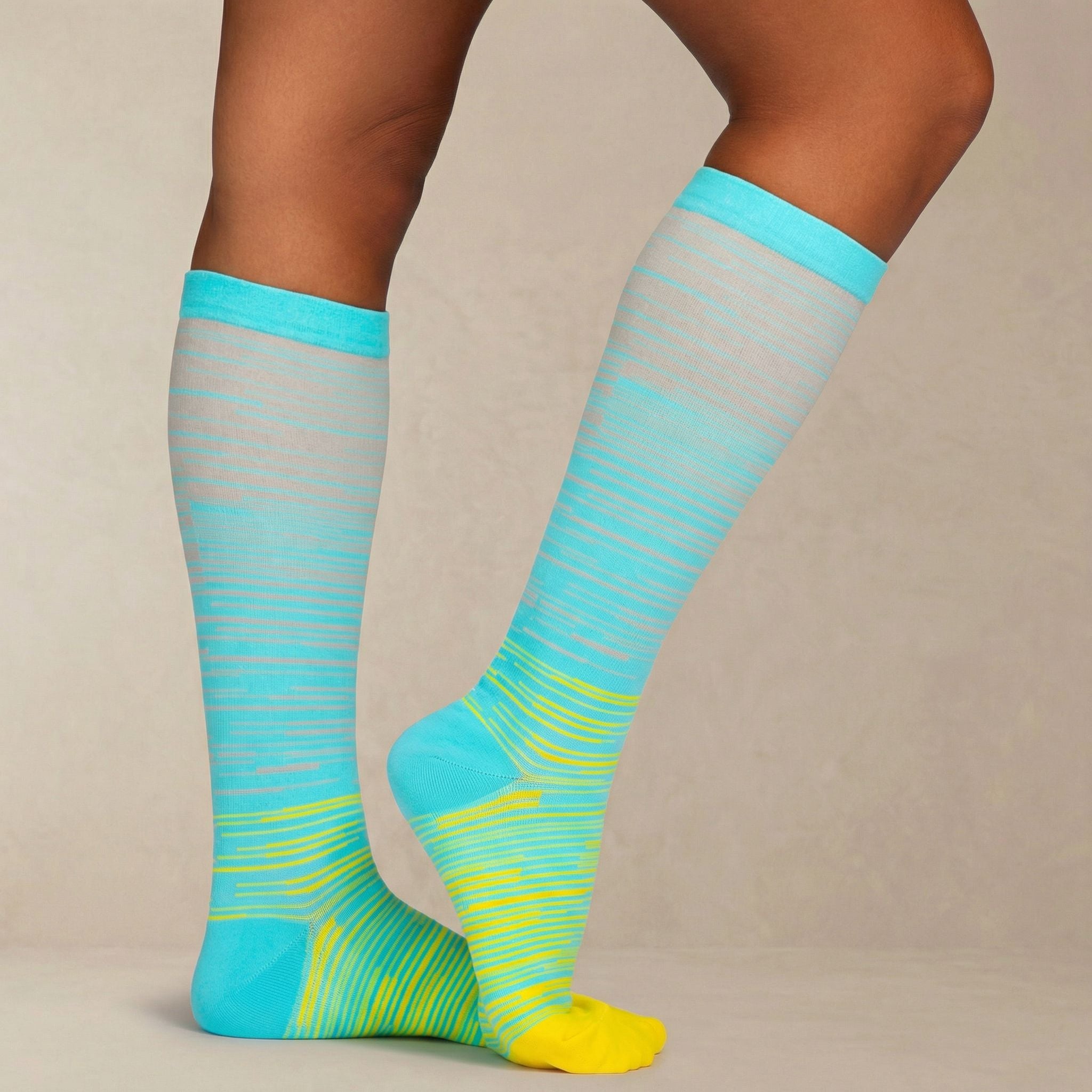 Teal and yellow striped knee-high compression socks on a neutral background