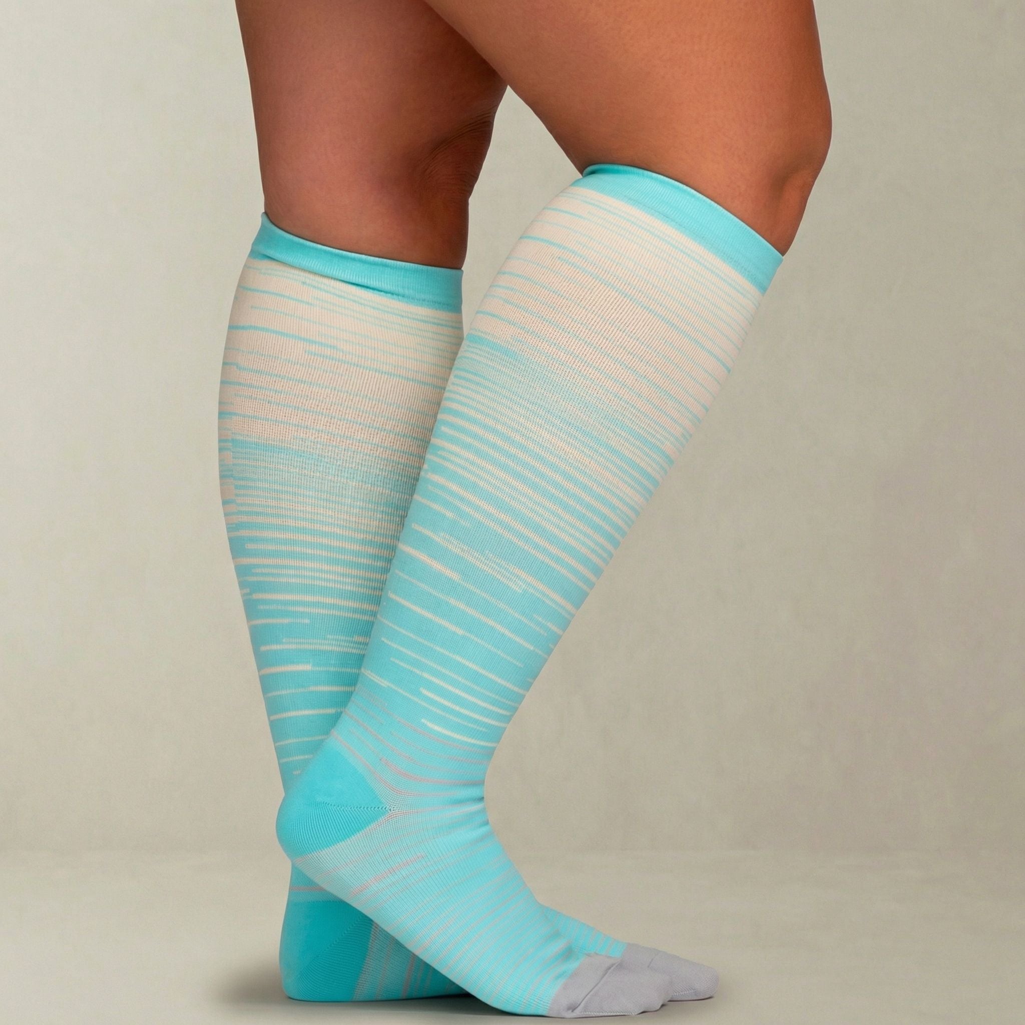 Teal and white striped knee-high compression socks on a neutral background