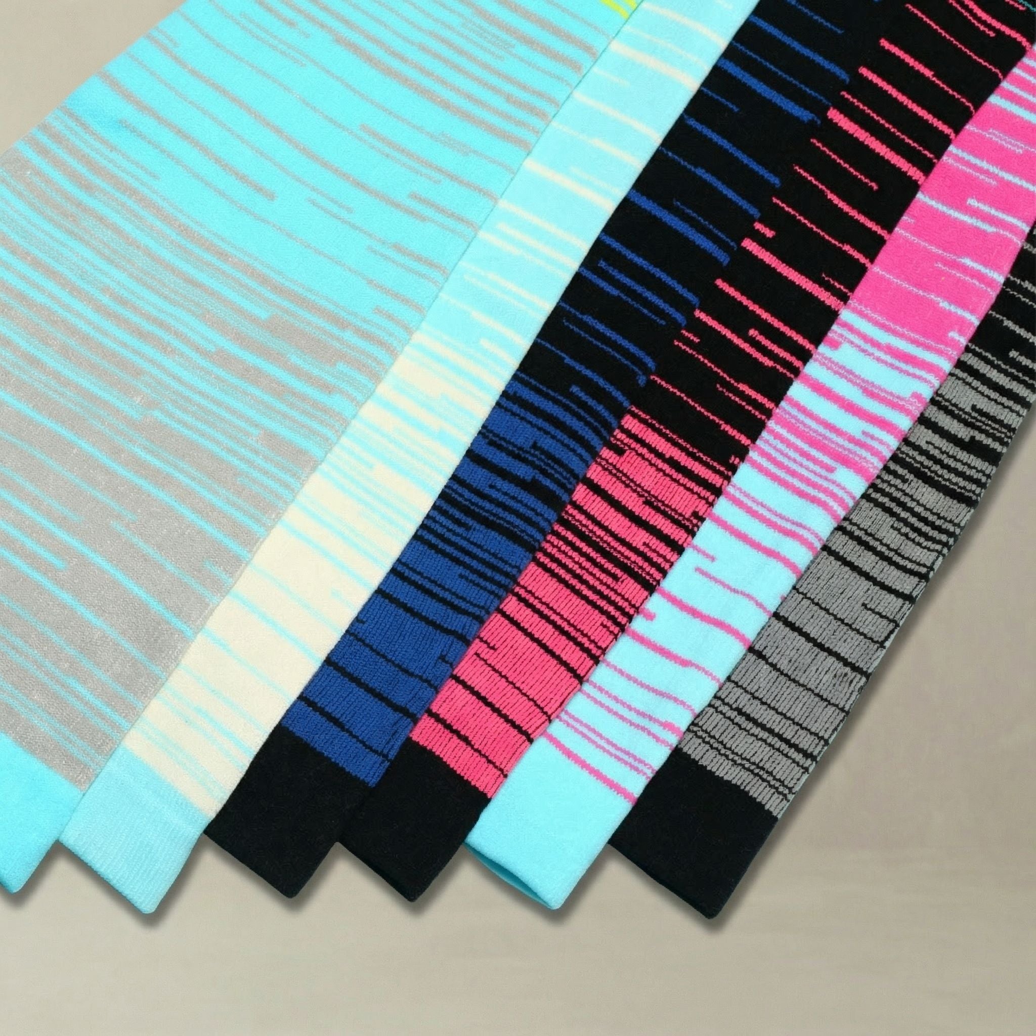 Set of colorful striped compression socks on a neutral background