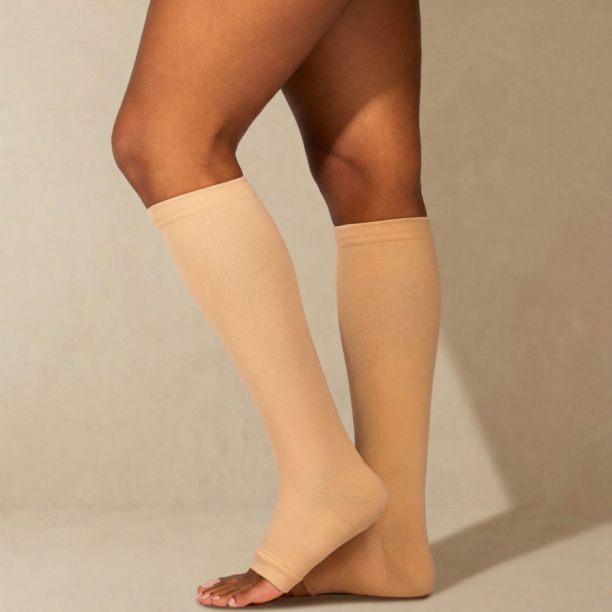 Beige compression stockings worn by a person on a beige background
