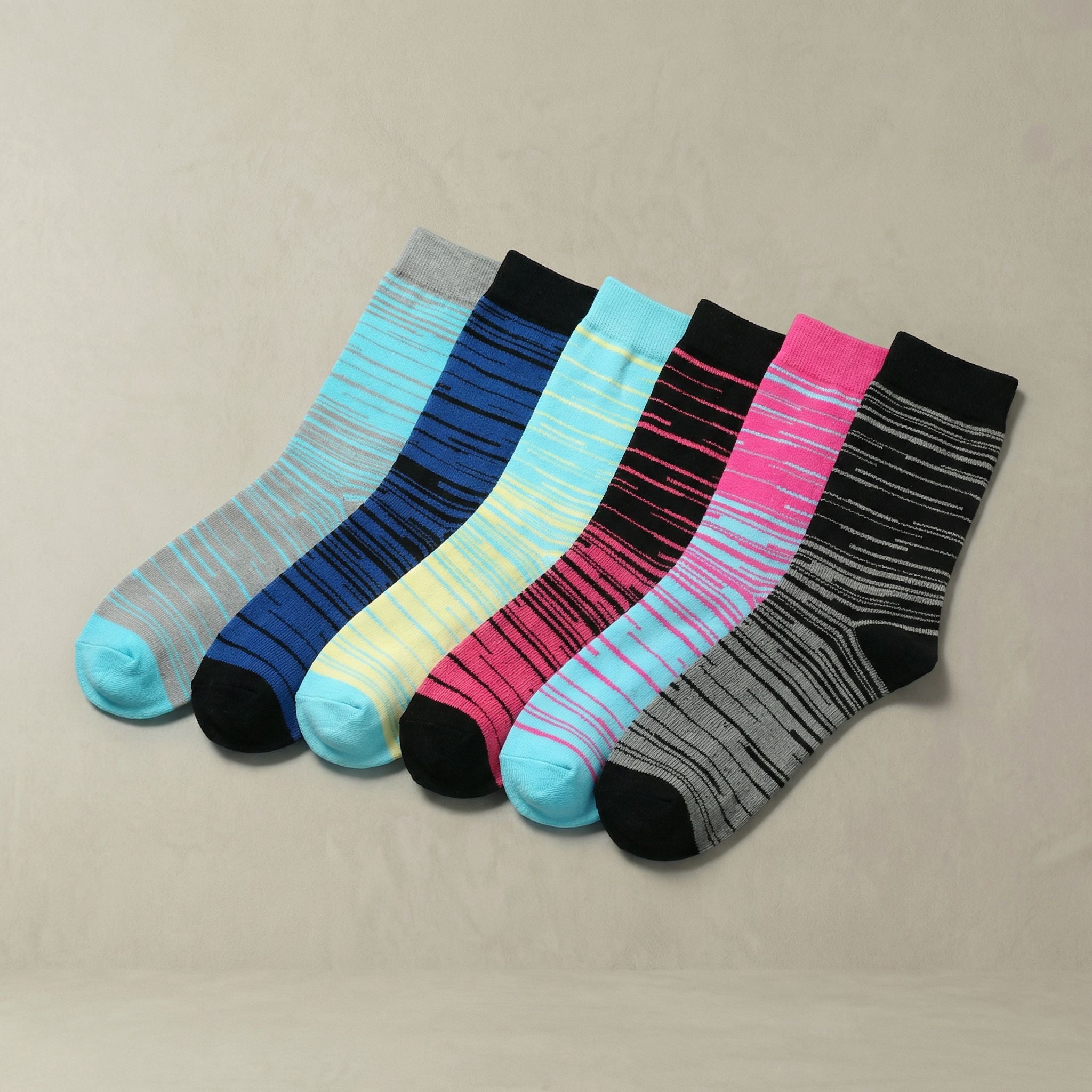 Set of colorful striped compression socks on a beige background